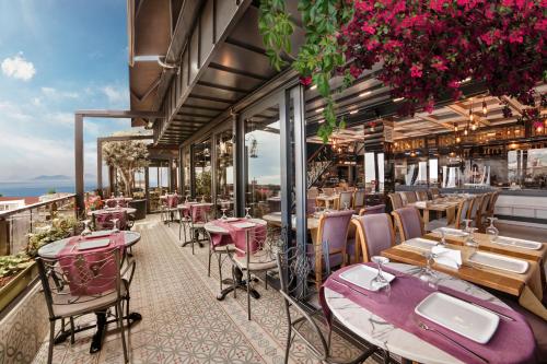 a restaurant with tables and chairs on a balcony at Skalion Hotel & SPA in Istanbul