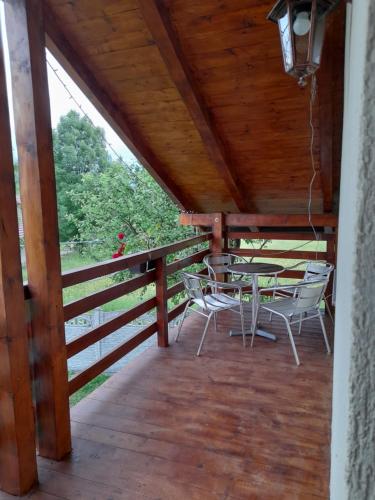 - une terrasse couverte avec une table et des chaises dans l'établissement Pensiunea Deny şi Dany, à Ribiţa