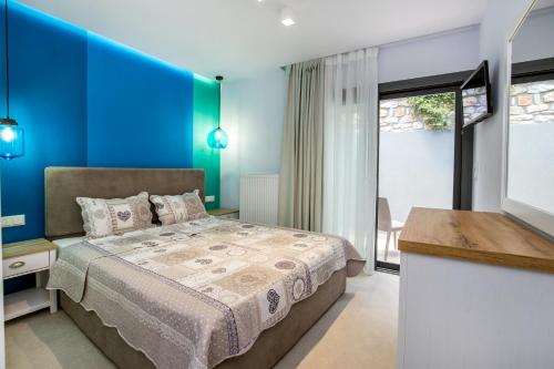 una camera con letto e parete blu di Oikos Daretsou a Theológos