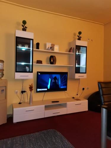a living room with a tv on a white entertainment center at Apartman Nik-Rom in Bosanska Gradiška