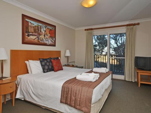 a bedroom with a large bed and a window at Villa 3br Vista Villa located within Cypress Lakes Resort in Pokolbin