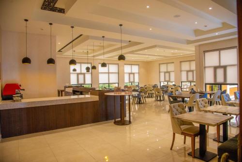 a restaurant with tables and chairs and a bar at Virunga Inn Resort & Spa in Kinigi