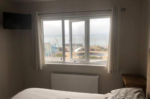 a bedroom with a window with a view of the ocean at Beautiful Sea view, Entire 2 bed Apartment, Portrush centre West Strand BeachView in Portrush