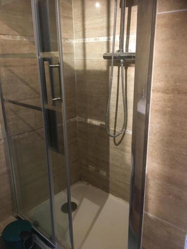 una doccia con porta in vetro in bagno di Garden Annexe 2 a Villeneuve-Loubet