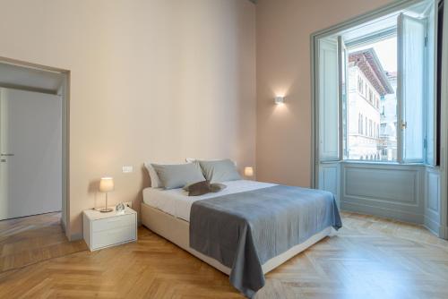 um quarto com uma cama e uma grande janela em Suite del Cardinale by MyHomeInComo em Como