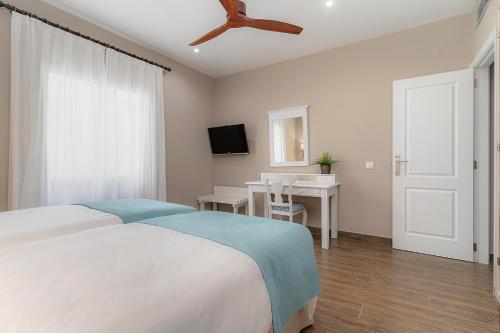 sypialnia z łóżkiem i wentylatorem sufitowym w obiekcie Natura Volcán By Vitalclass Lanzarote Resort w Costa Teguise