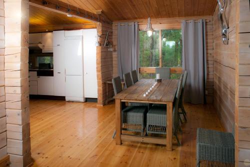 jadalnia z drewnianym stołem i kuchnią w obiekcie Villa Bergholmen w mieście Taalintehdas