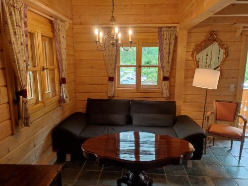 a living room with a couch and a table at Schlosswirt Chalets & Apartments in Großkirchheim