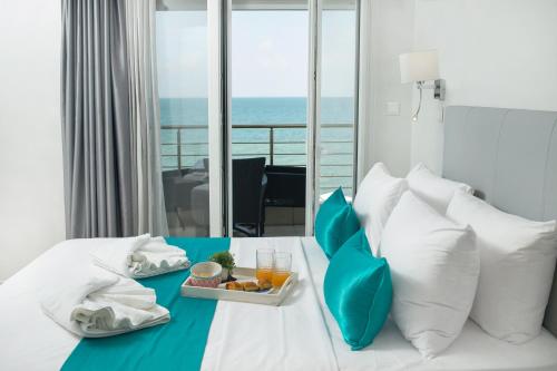 a hotel room with a tray of food on a bed at Lux VIP Apartments in Perea