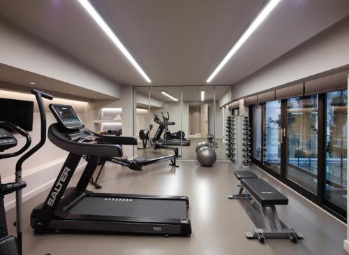 a gym with two treadmills and two ellipticals at Heritage Hill Hotel in Athens