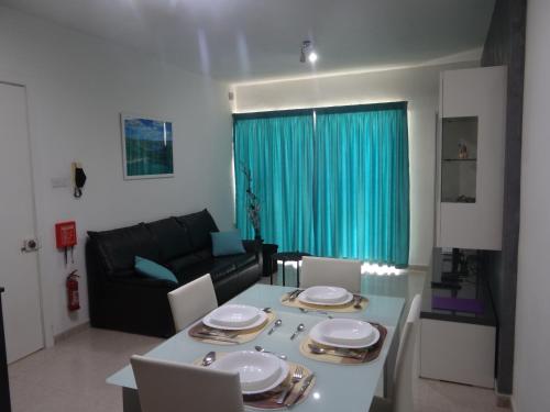 a living room with a table and a couch at Modern Two Bedroom Sea View Apartment in Marsaskala