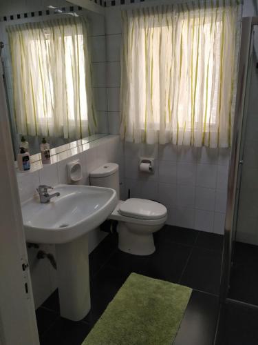a bathroom with a white toilet and a sink at Modern Two Bedroom Sea View Apartment in Marsaskala