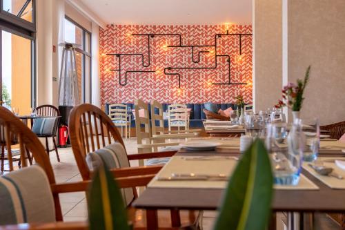 a dining room with tables and chairs and a chandelier at Aqua Natura Bay in Porto Moniz