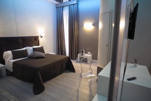 a bedroom with a bed and a dresser in a room at Piccolo di Piazza di Spagna Suites in Rome