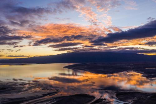 a sunset over a body of water with clouds at Africa Safari Lake Natron Camping in Mtowabaga