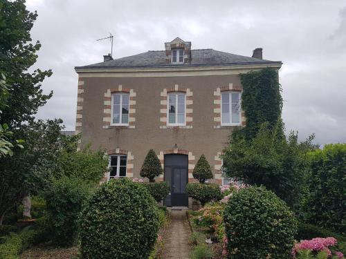 a large brick house with a door and bushes at Gîte Mido in Cordemais