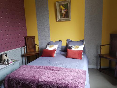een slaapkamer met een bed met 2 kussens bij Gîte Mido in Cordemais