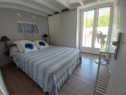 ein Schlafzimmer mit einem Bett mit blauen Kissen in der Unterkunft Maison de pecheur in Sigean
