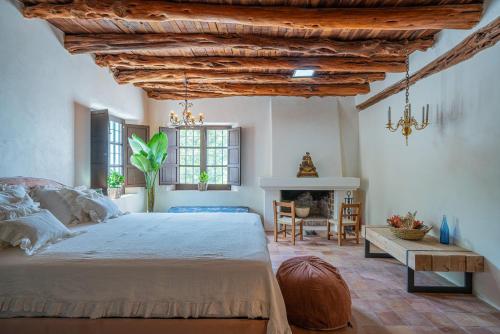 a bedroom with a large bed and a fireplace at ROBBY'S ibiza in Sant Josep