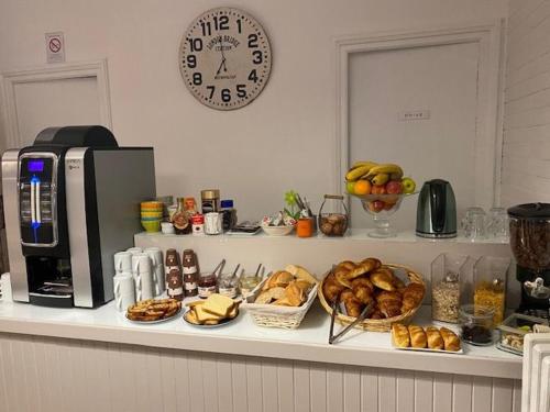 a counter with a bunch of bread and a clock at Hôtel La Villa Lorraine in Toul