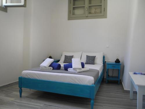 a bedroom with a blue bed and a blue table at Era Tefra in Éxo Goniá