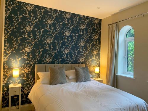 a bedroom with a bed with a black and gold wallpaper at Crossing Cottage sleeps 6 with private parking,ideal for contractors , Newark in Staythorpe