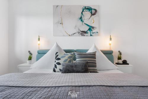 a bedroom with a bed with pillows and a painting at Blue Horizon in Olpenitz