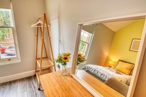 a mirror in a bedroom with a bed and a window at 2 Bedroom Apartment, NEC, HS2, BHX, JLR - Devereux House, Hosted By Coventry Accommodation in Coleshill