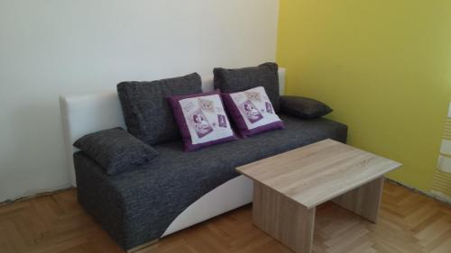 a couch with two pillows and a table at Gasthof Altes Hammerherrenhaus in Übelbach