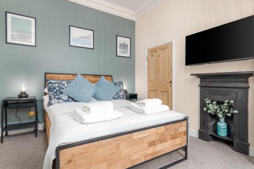 a bedroom with a bed with a fireplace and a flat screen tv at Host & Stay - Railman's Rest in Whitby