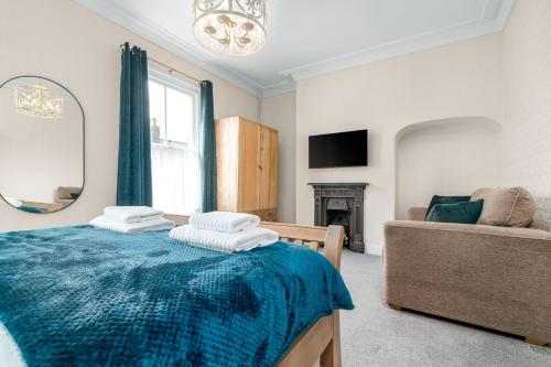 a bedroom with a bed and a couch and a mirror at Host & Stay - Railman's Rest in Whitby