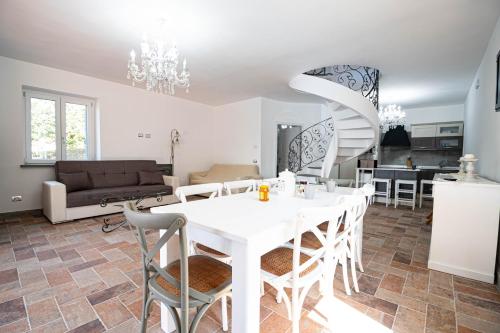 a dining room and living room with a white table and chairs at luxury villa Arianna in Tarano