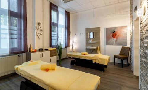 a hospital room with two beds and a chair at Hotel Badehof in Bad Salzschlirf