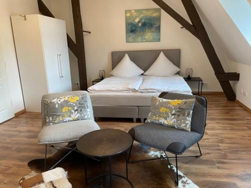 una camera con un letto e due sedie e un tavolo di FEWO Schlossberg Weingut C.A. Haussmann a Traben-Trarbach