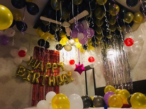 a table with a happy birthday sign and balloons at Sai Sharan Stay Inn- Near MIDC Turbhe Navi Mumbai in Navi Mumbai