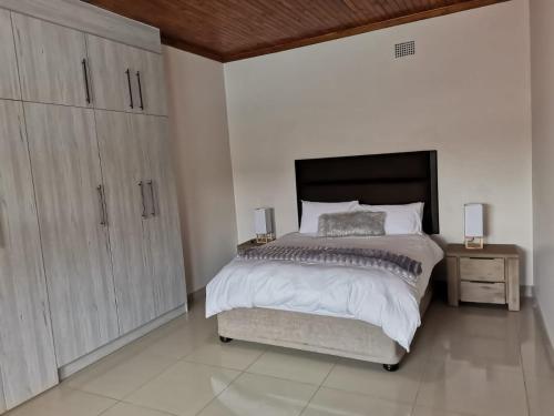 1 dormitorio con 1 cama grande y armario grande en @Anderson Executive Suites, en Kimberley