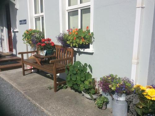 a bench in front of a building with flowers in a window at Doolin Lanelodge -Room Only- in Doolin