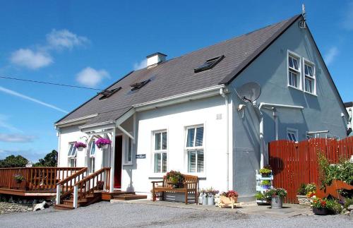 ein weißes und graues Haus mit einem roten Zaun in der Unterkunft Lanelodge -Room Only- in Doolin