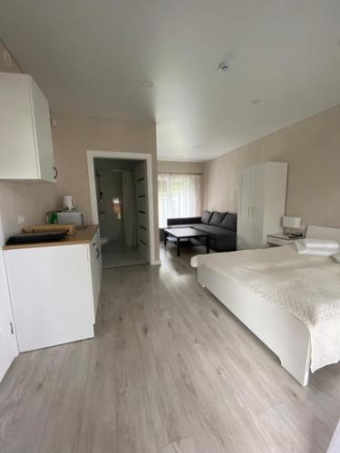 a bedroom with a white bed and a couch at Vila KOPA Šventoji in Šventoji