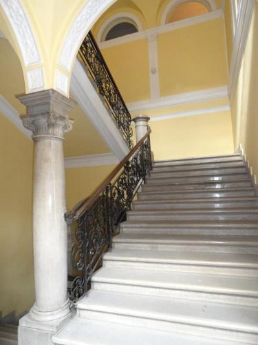 a staircase in a building with a column at Boudoir Budapest Apartment in Budapest