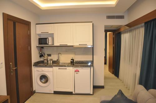 a kitchen with a washing machine and a microwave at GOLAZ SUİT OTEL in Ankara