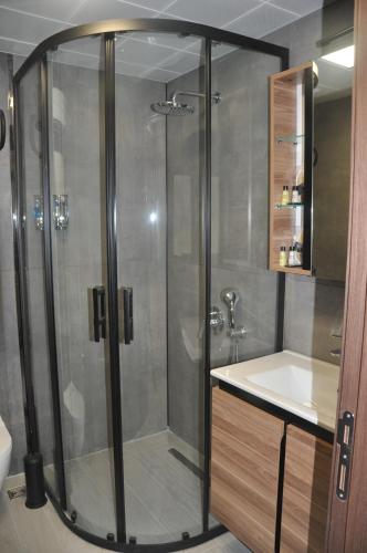 a bathroom with a shower with a sink and a toilet at GOLAZ SUİT OTEL in Ankara