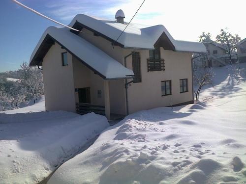 a house covered in snow with a pile of snow at Guest House Tena in Slunj