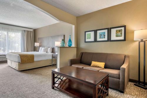 a hotel room with a bed and a couch at Comfort Suites Sawgrass in Tamarac