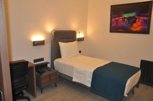 a bedroom with a bed and a desk and a television at GOLAZ SUİT OTEL in Ankara