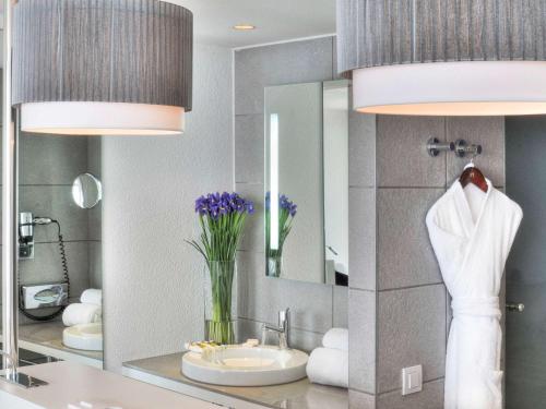 La salle de bains est pourvue d'un lavabo et d'un miroir. dans l'établissement Mercure Nice Promenade Des Anglais, à Nice