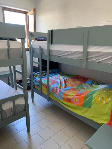 - une chambre avec 2 lits superposés et une chaise dans l'établissement Sète - Confortable appartement T3 climatisé 6 personnes avec garage - 150 m de la plage, à Sète