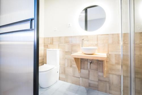 a bathroom with a toilet and a sink at OLBLANC Plaza de España by Batuecas in Madrid
