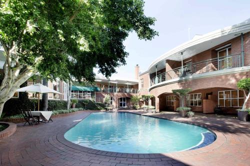 uma piscina no pátio de um edifício em Premier Hotel Falstaff em Joanesburgo