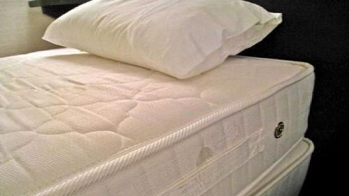 a white bed with a pillow on top of it at Hotel Crown Hills Niigata in Niigata